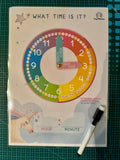 Educational clock poster for learning time with a marker on a green cutting mat.