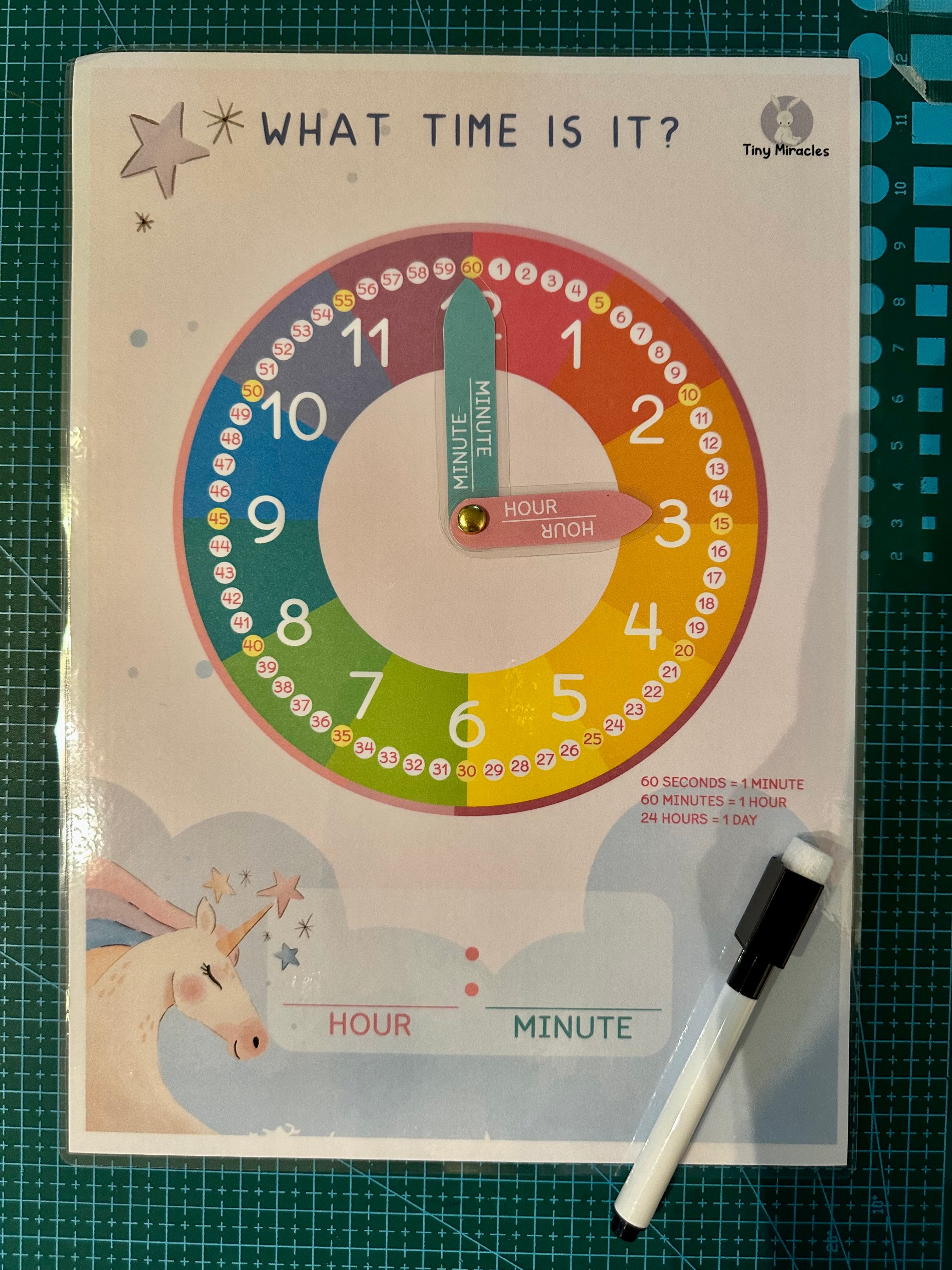 Educational clock poster for learning time with a marker on a green cutting mat.